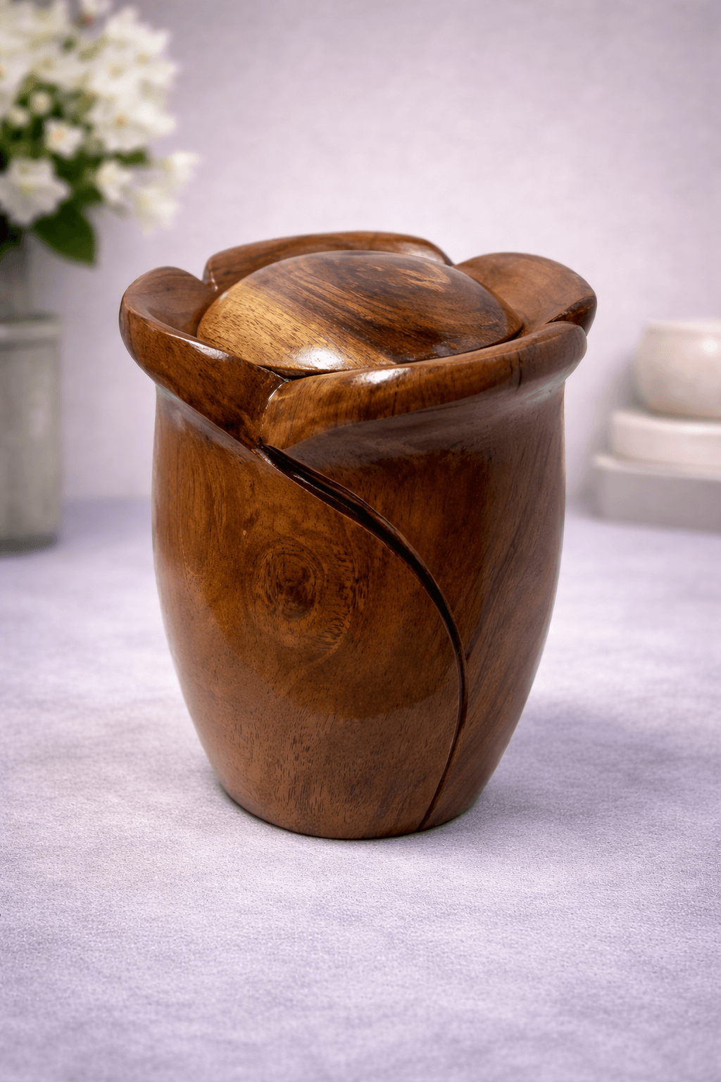 Artistic handcrafted wooden urn with a sculpted contemporary design and natural polished finish